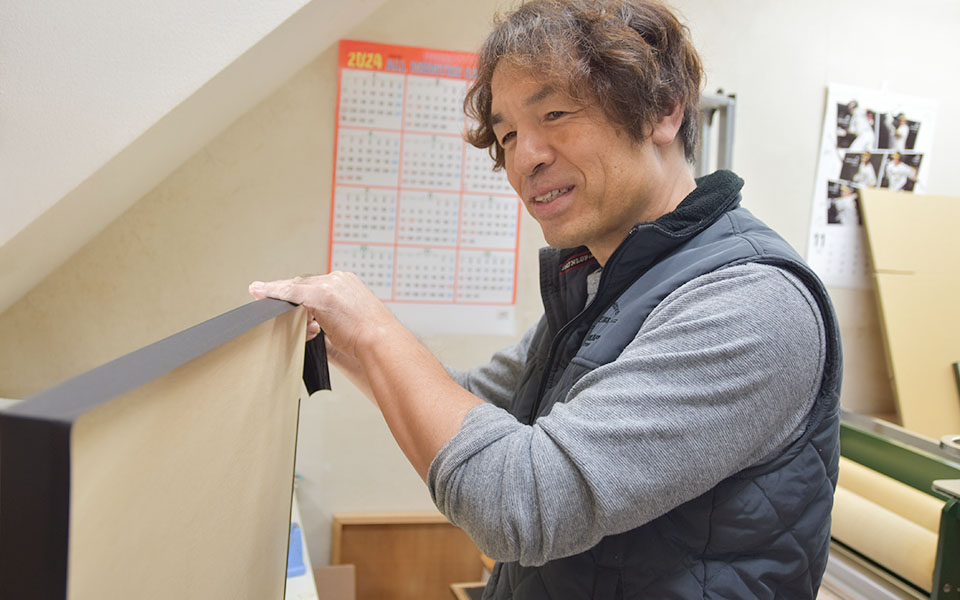 フォトパネルドットコム代表のマット紙を貼る作業風景